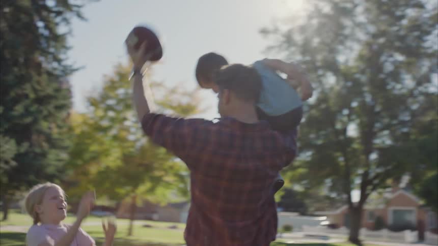 Father plays with his kids in the park at morning
