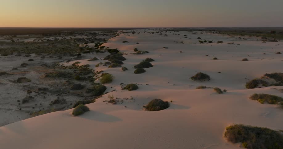 Aerial view of sand dunes in the desert at sunset
