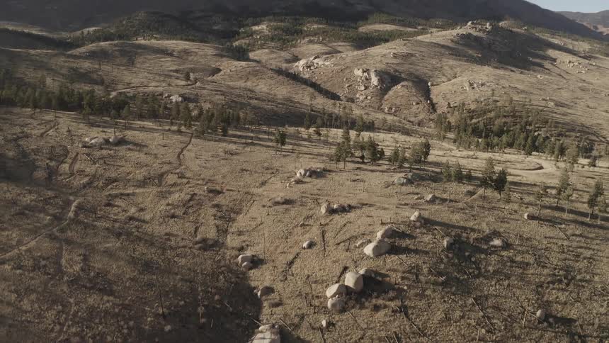 Aerial panorama of dry land surrounded by a chain of mountains