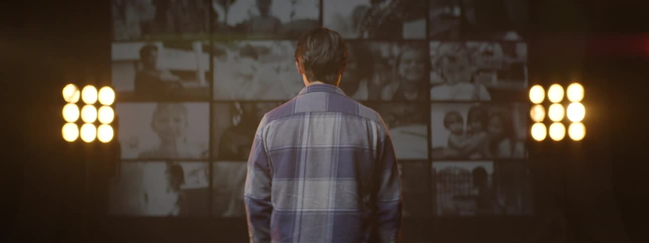Boy with his back to the camera watching a video on projections in an indoor room