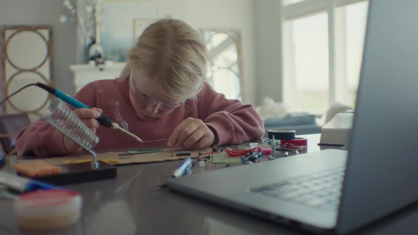 Girl soldering a small hardware device