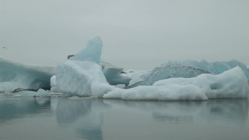 Large blocks of ice float in the water ahead