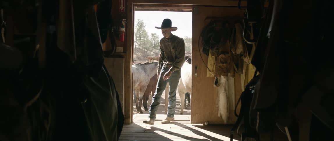 Cowboy enters a storage shed in the ranch