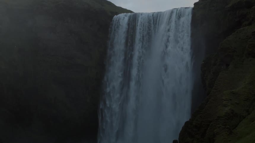 A waterfall is pouring water down below on a cloudy day
