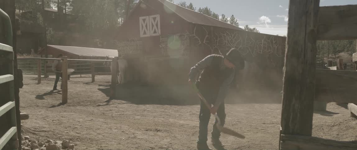 A man scooping sand with a hand tool in a country area