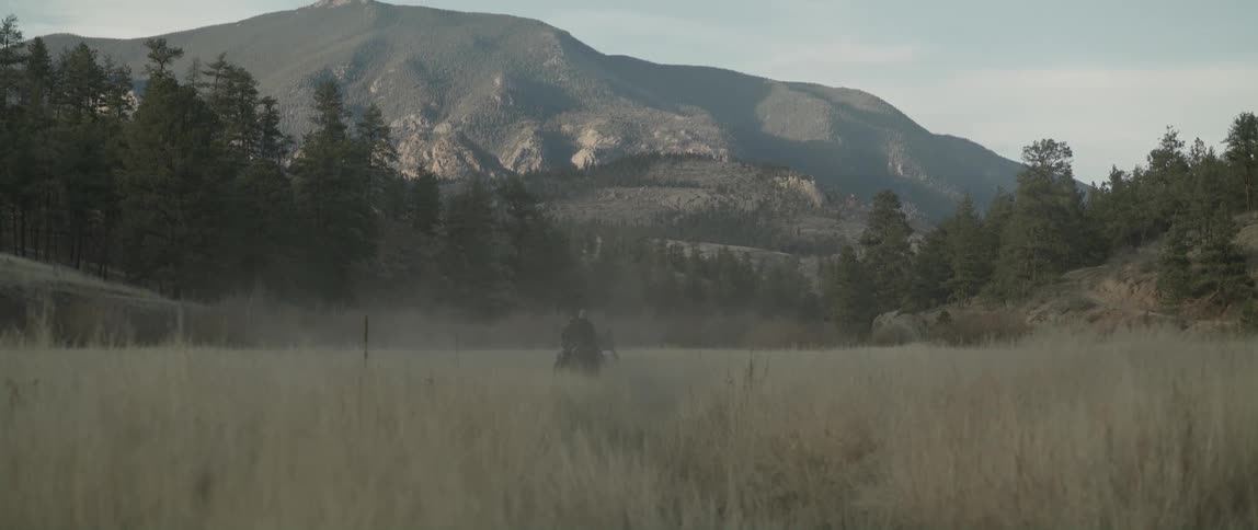 People moving on horses at midday towards a mountain