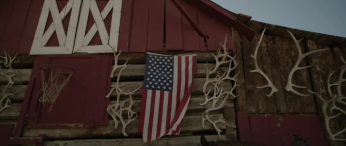 American flag waving on the wall of a barn