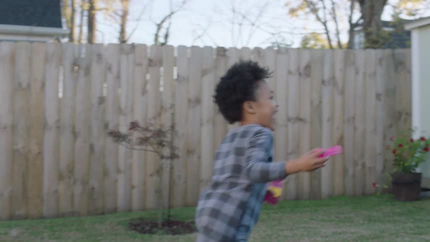 Man and his children plays around at the backyard during the day