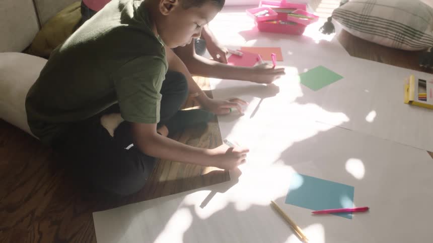 Siblings doing homework crafts and arts at home