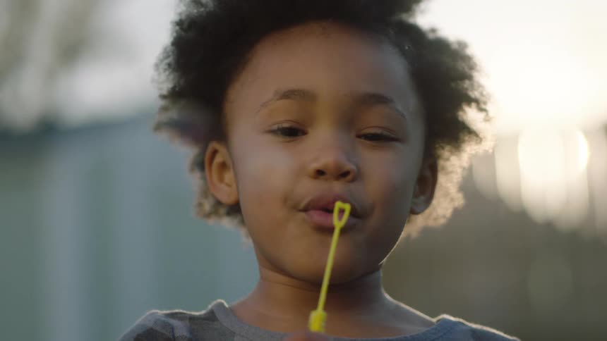 Little girl blowing a bubblemaking toy