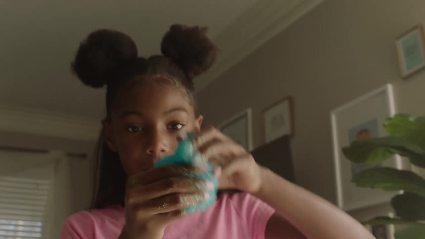 Girl at home plays with blue slime