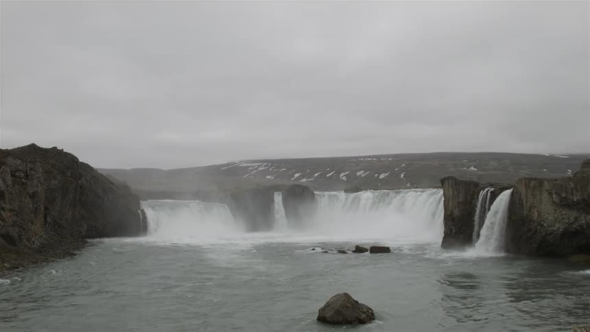 Wide view of some waterfalls on a cloudy day