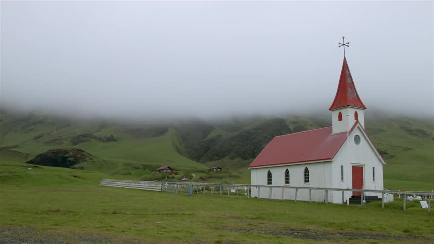 Country church sitting amongst greenery with a very hazy sky