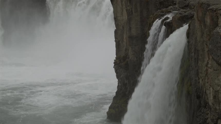 A large waterfall is spraying mist everywhere