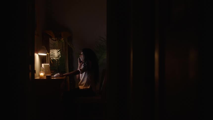 A woman working on a laptop at night