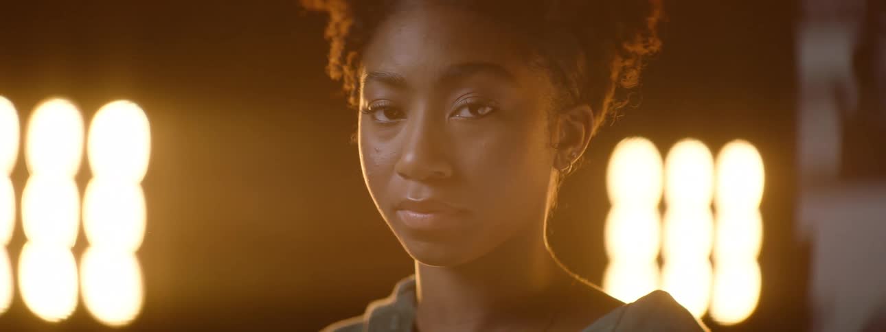 A sad girl illuminated by yellow lamps