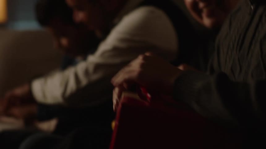 Portrait of people sitting on a sofa opening gifts
