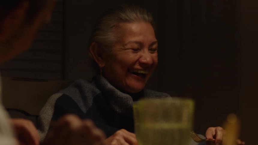 Portrait of people sitting at a dining table talking and smiling