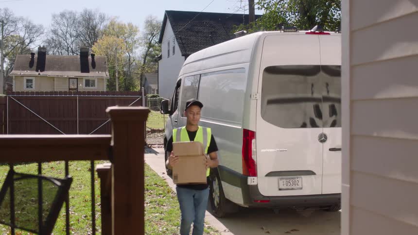 Delivery man brings boxes to the porch