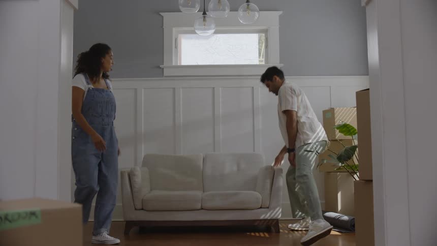 A couple tidying up the living room after moving