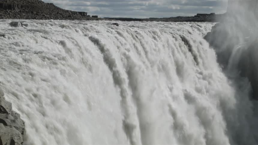 A waterfall is bursting water over the edge