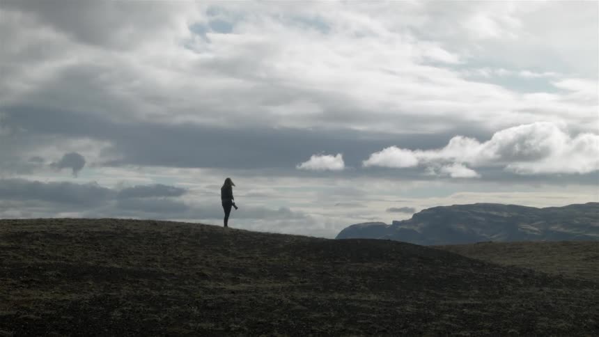 Person standing out in the open wilderness on a very cloudy day