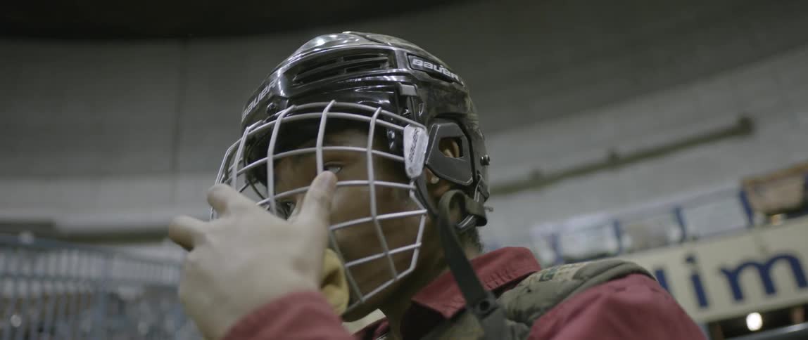A man puts on a gated helmet