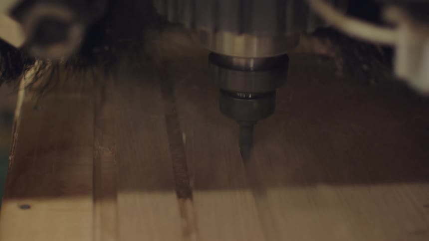 Machine carves parallel channels in wood and releases sawdust