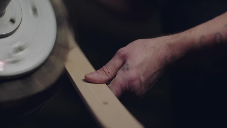 A person sanding wood on a wood sanding machine