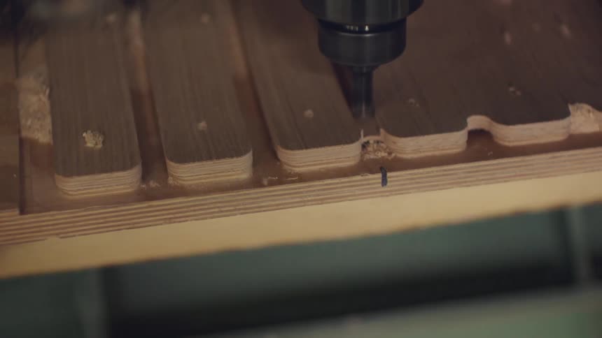 Machine cutting a wooden board