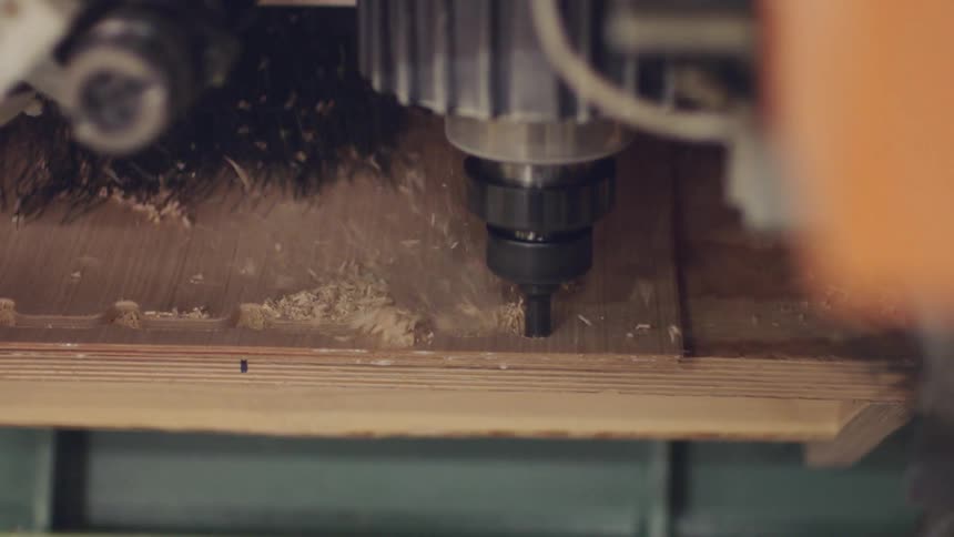 Machine cutting a wooden board