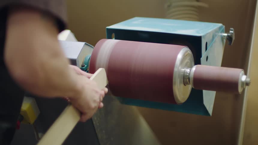A person shaping wood on a rotating lathe