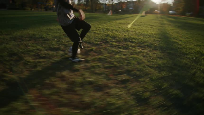 Boy practices soccer on a field in the morning