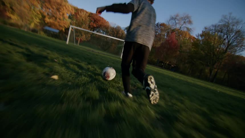 A football player kicking the ball into the goal