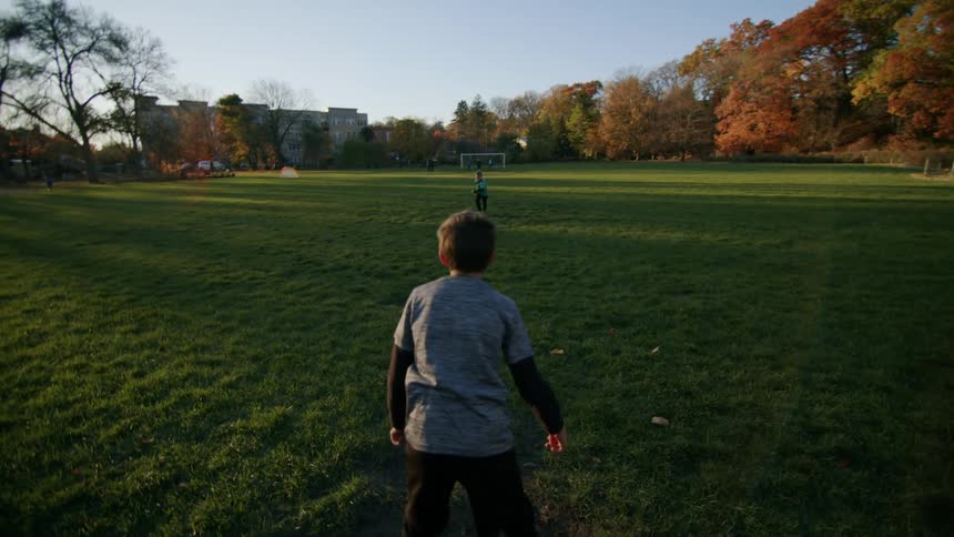Two boys play soccer ball on the soccer field
