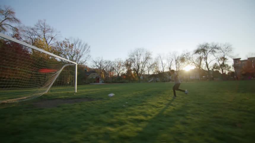 Boy getting up running and scoring a soccer goal