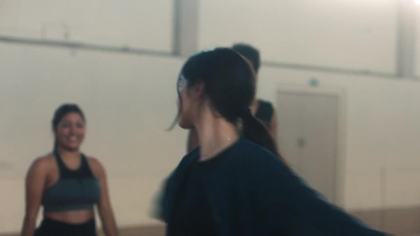 People stand around watching as a woman dances ballet