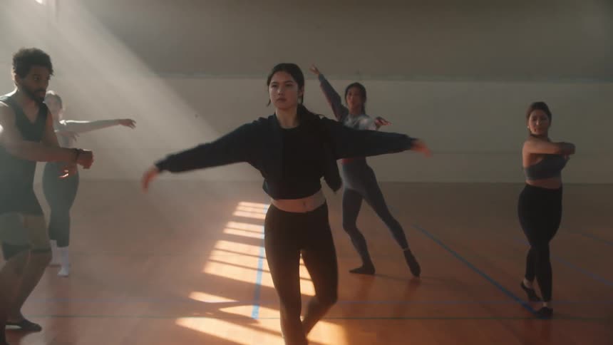 Teacher assisting students in performing a ballet turn