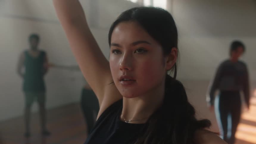 A ballet dancer practices her moves in front of her friends refining her skills in a supportive atmosphere