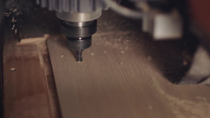 Machinery performing a cut on a wooden board