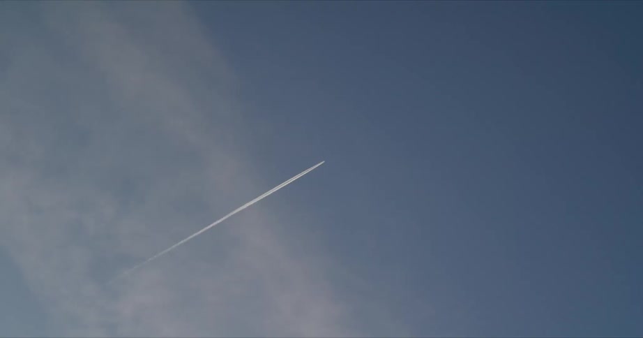 Aircraft leaves contrail through cloudy sky