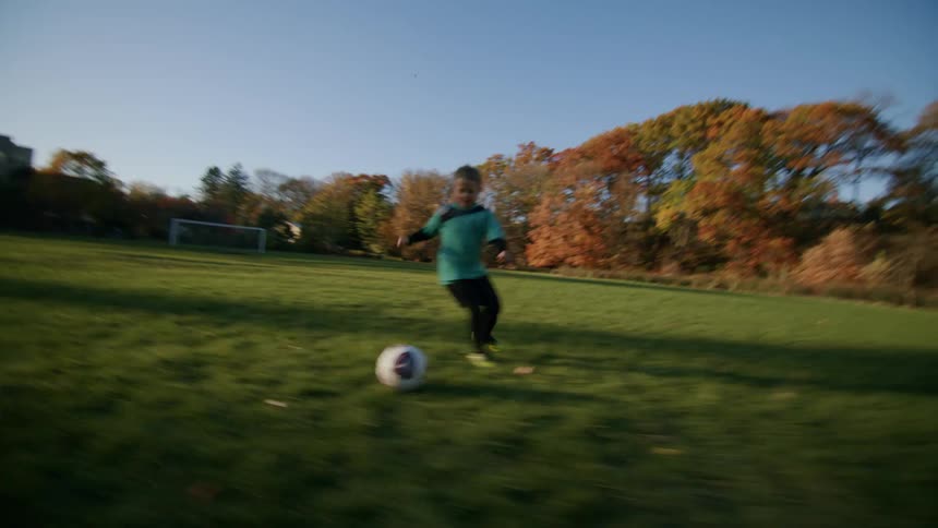 A footage of two kids playing football on the field