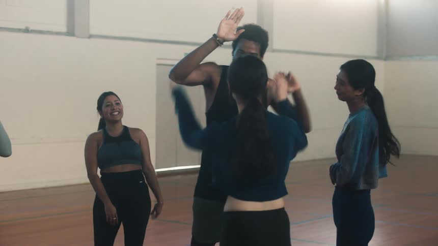 Dancers celebrating on a court while rehearsing
