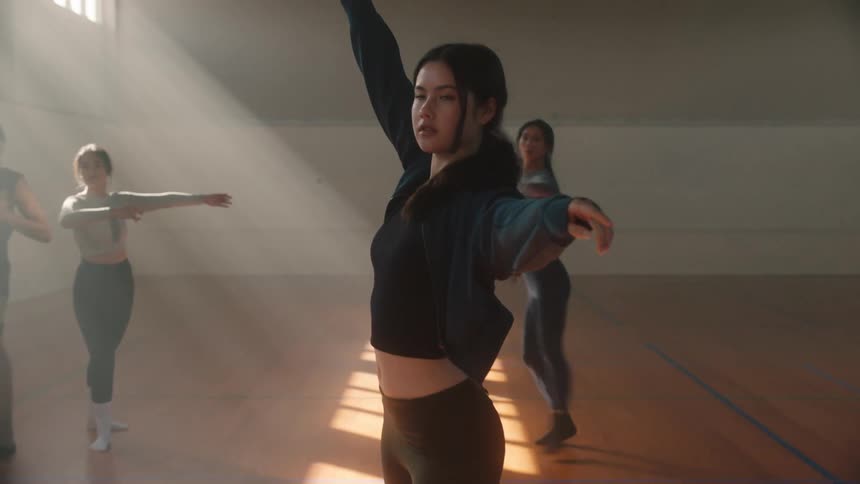 Ballet dancers in a group practicing graceful movements in a ballet rehearsal