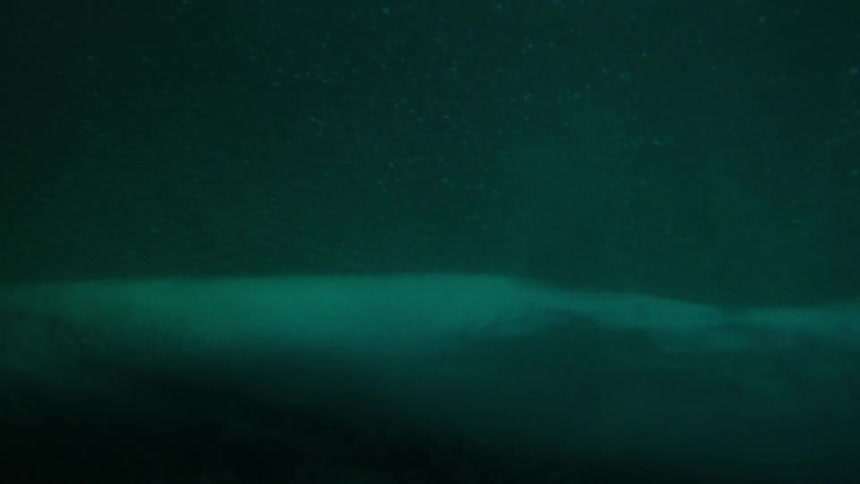 View from inside the sea of a wave breaking with clear waters