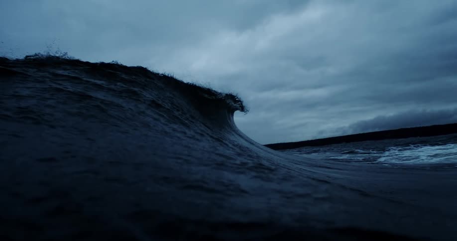 A large wave on a raging sea during dusk