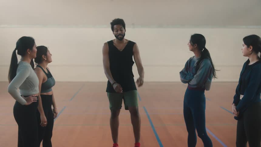 Teacher hopping along with his students in a cardio workout then joining arms and hands together in celebration