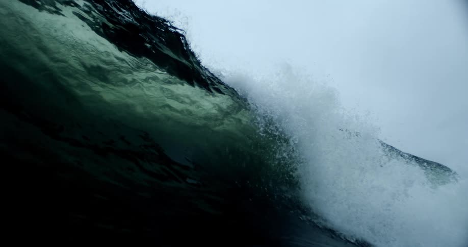 A sea wave crashing hard during the day