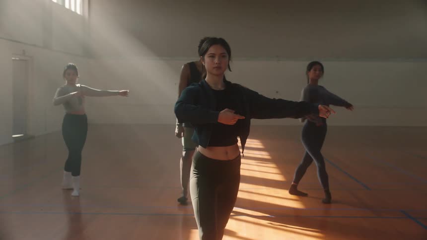 Teacher watching his students perform a spinning ballet movement