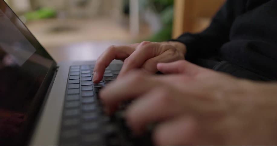 Closeup on the hands of a person typing on a laptop
